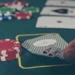 A person looking at their hole cards in a poker game.