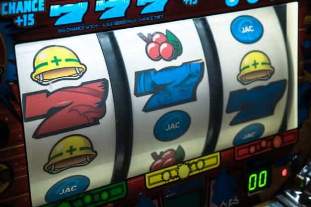 Slot machine displaying three sevens.