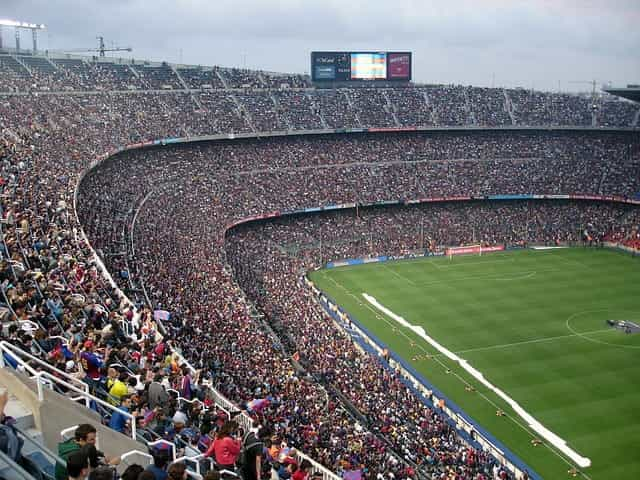 A huge sports stadium filled to the brim with spectators watching a large-scale sporting event.