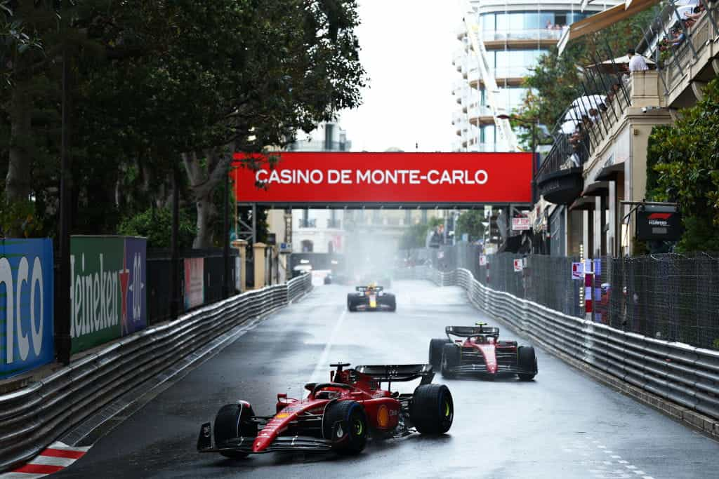 Charles Leclerc racing on wet Monaco streets in 2022.