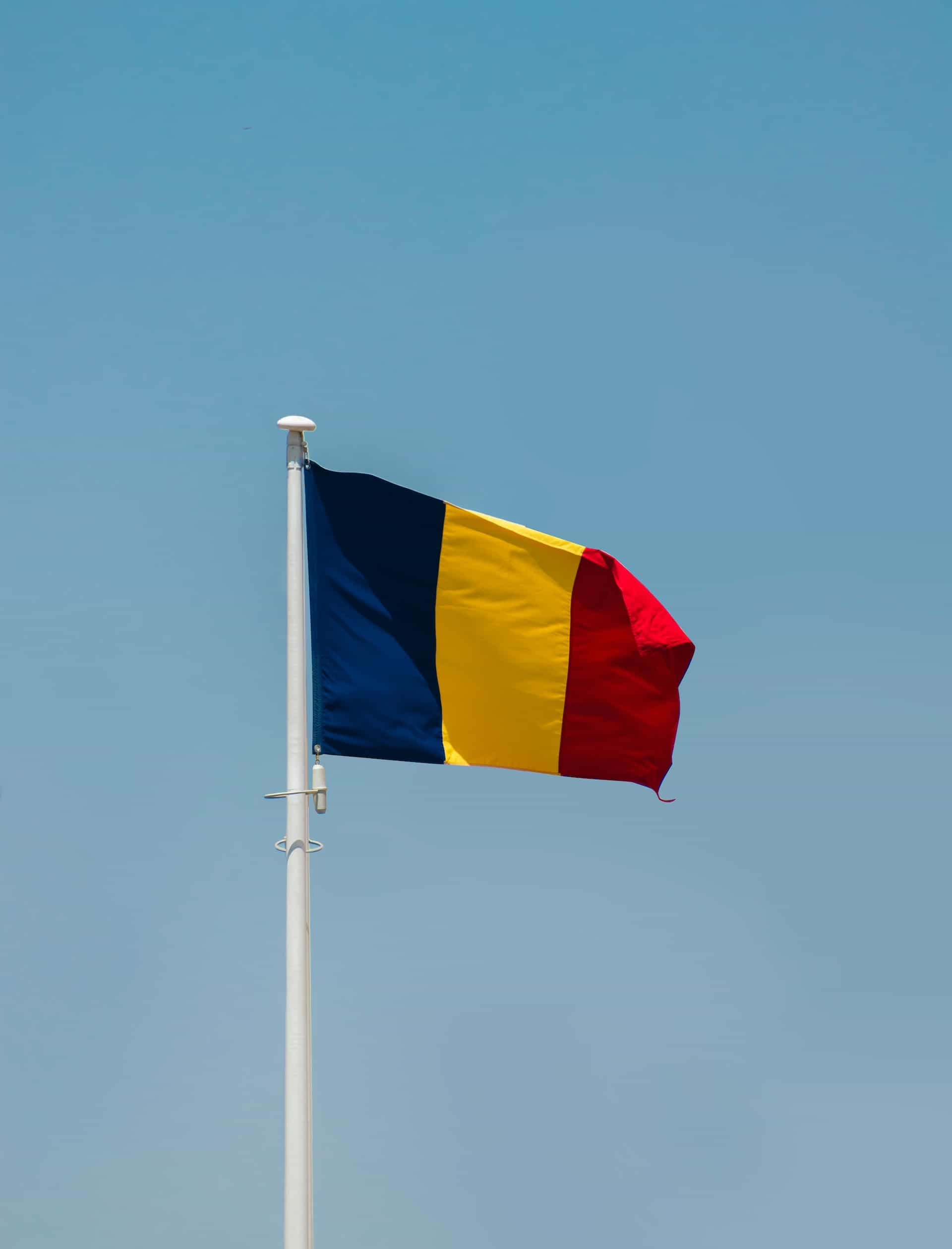 The Romanian flag against a blue sky.